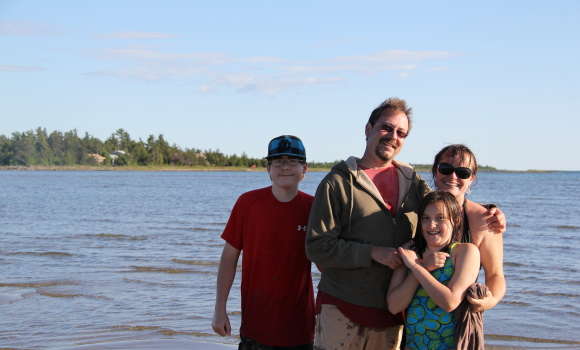 Family posing for photo infront of lake