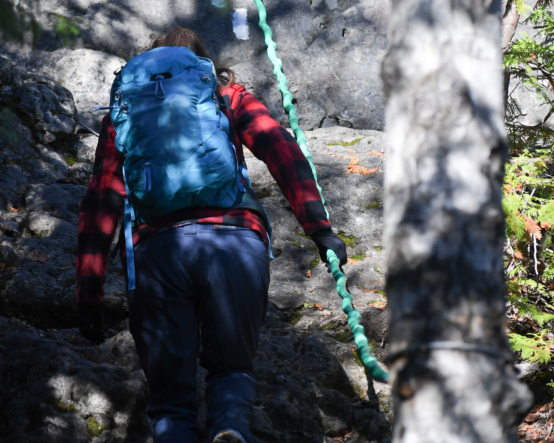 Woman backcountry hiking, following a rope guide on the Bruce Trail