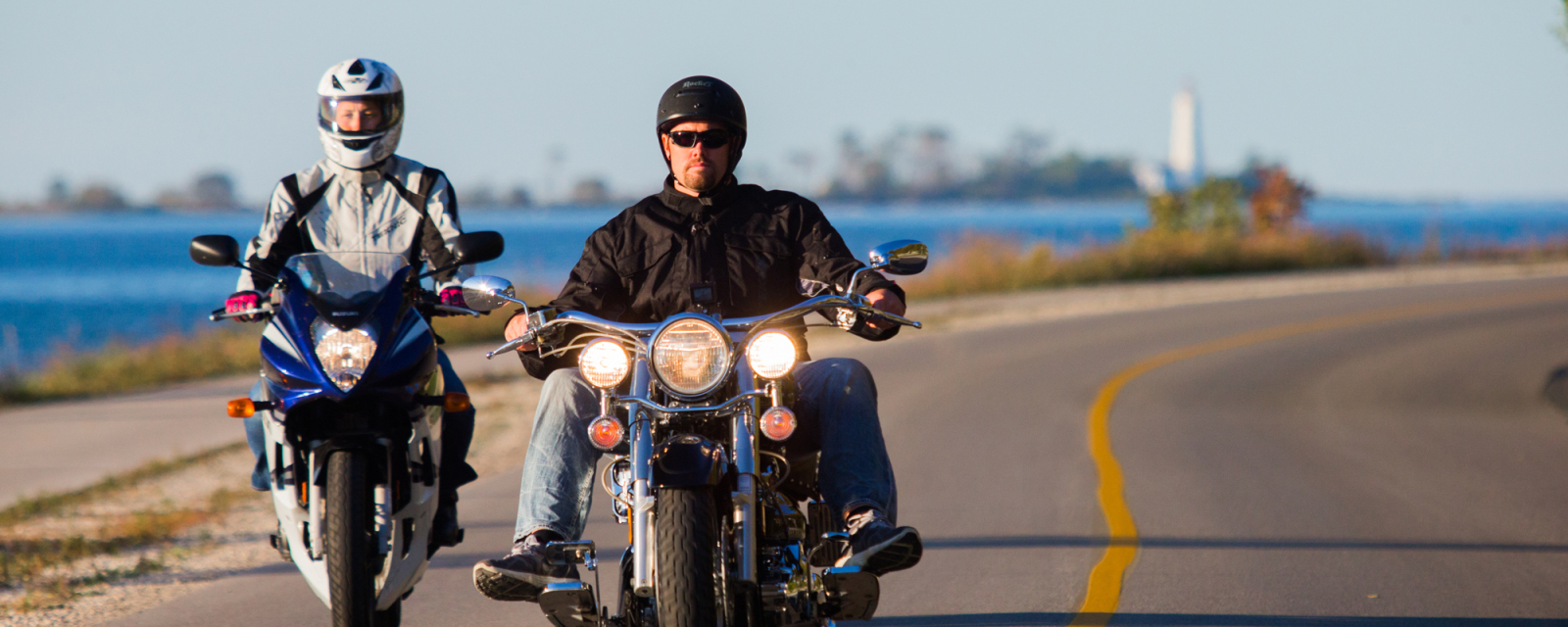 Two men on motorcycle tour along the shoreline