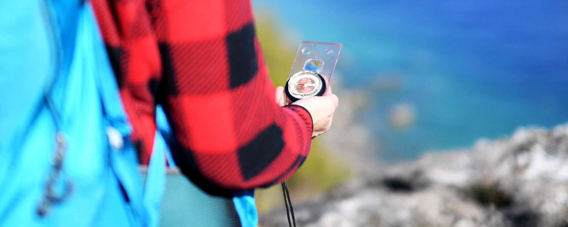 close up of a person holding a compass while back country hiking