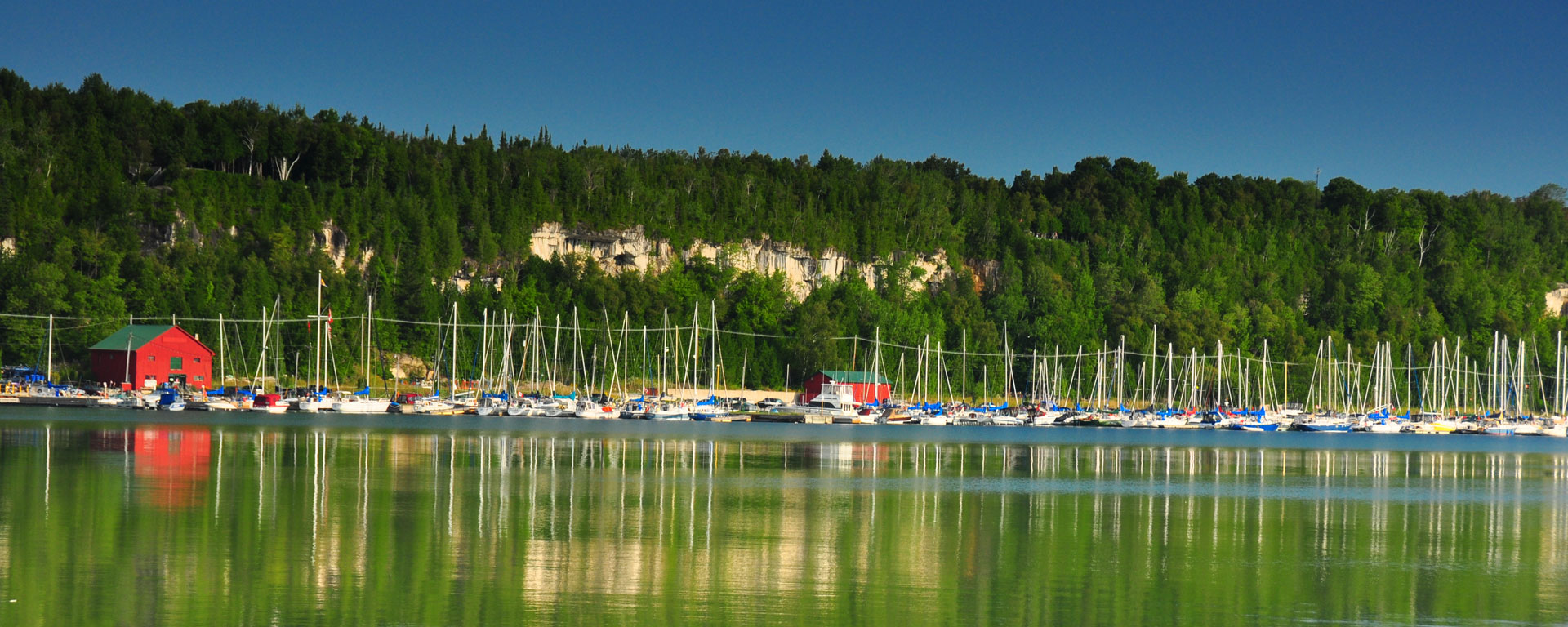 A wide shot of a marina in Wiarton. The surface of the lake is still