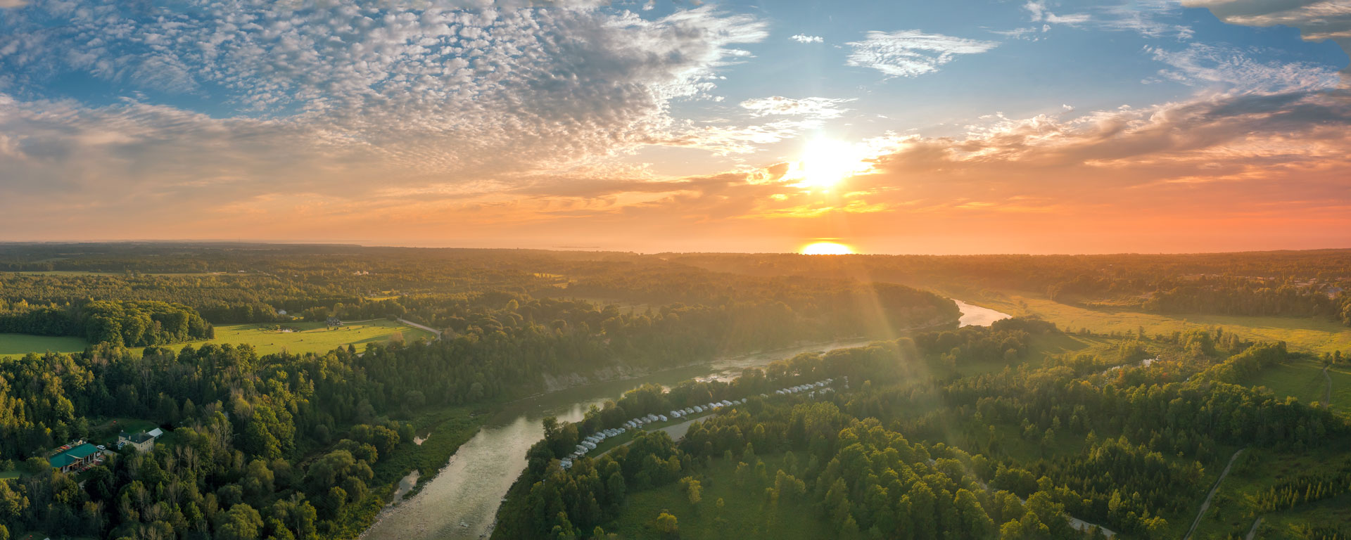 drone shot looking down at the saugeen river with a blue gold sunset