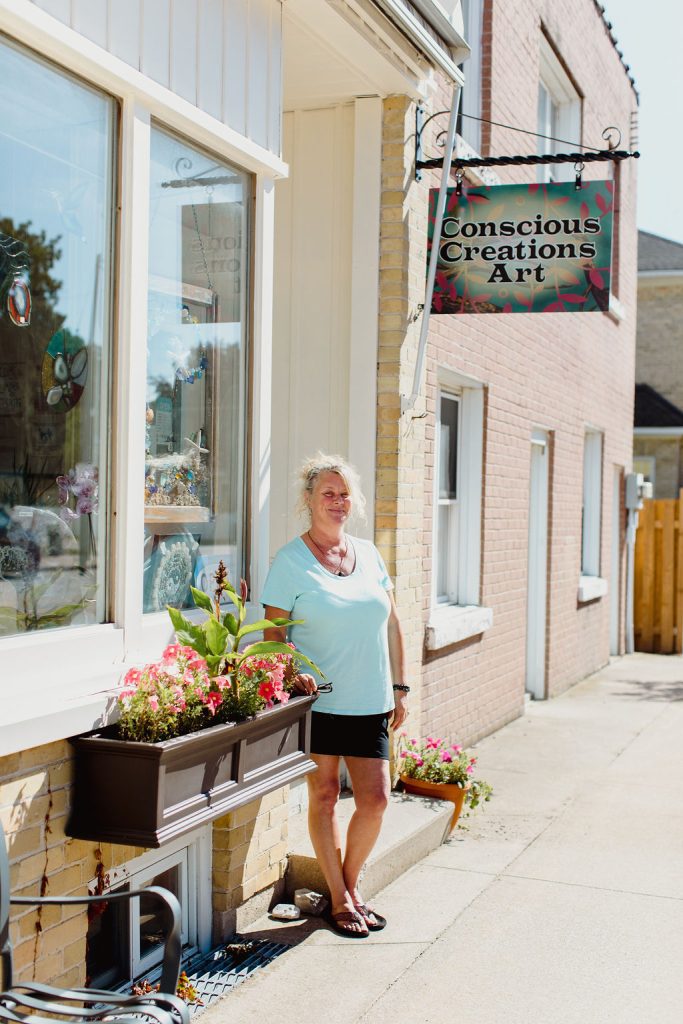 Local woman standing outside her storefront "Conscious Creations Art"