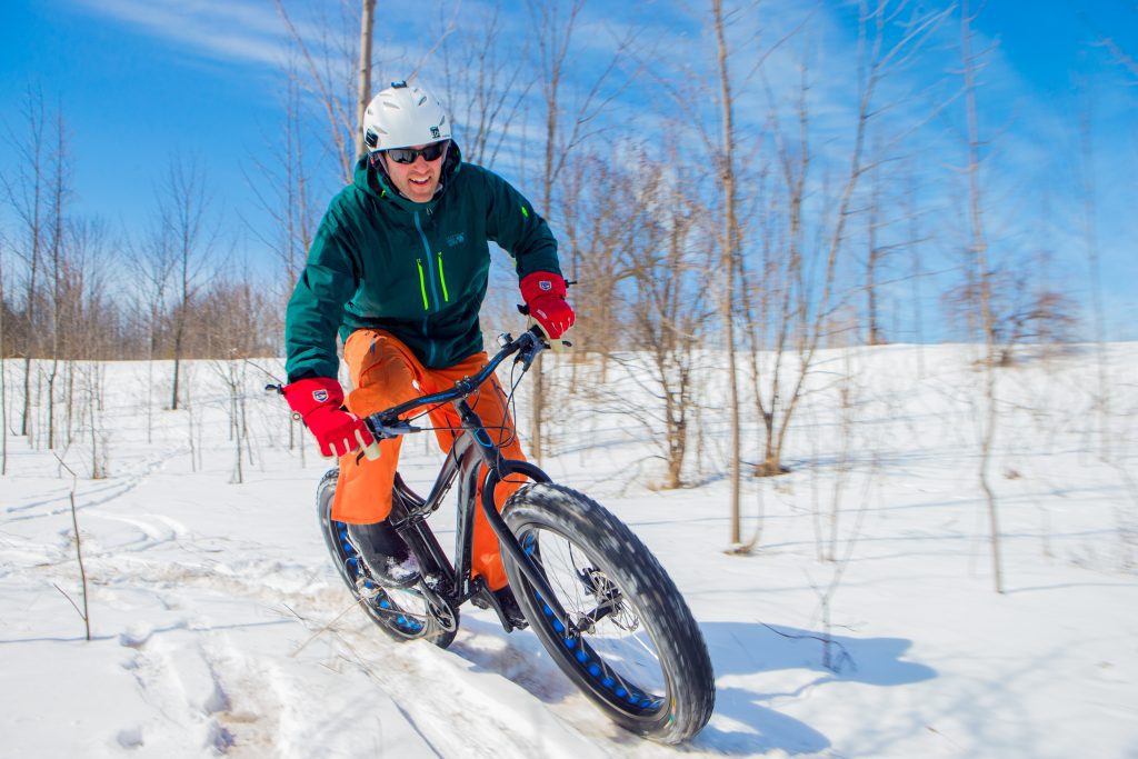 Person riding fat bike in winter landscape