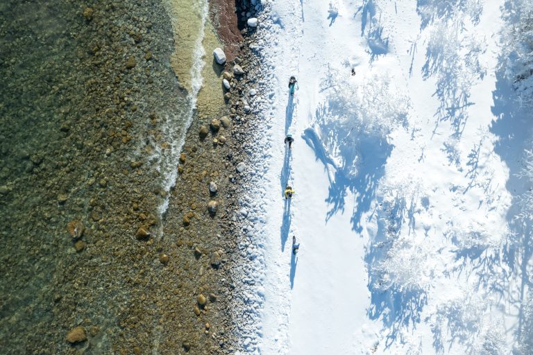 People hiking along sandy and snowy Bruce County shoreline