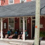 A group of people sitting outside a historic Inn