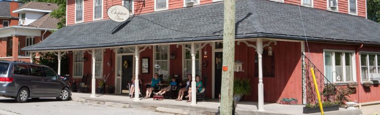 A group of people sitting outside a historic Inn