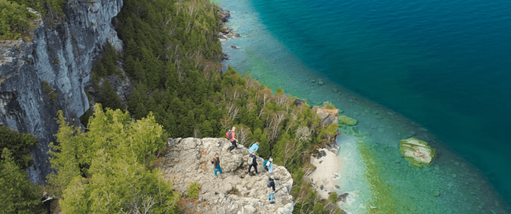 A group of people standing near a cliff's edge